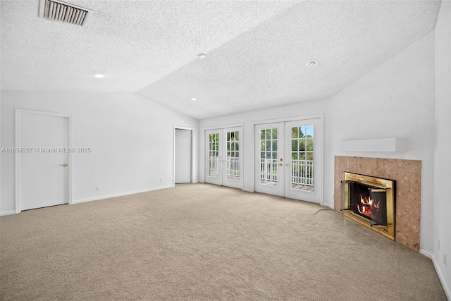 7545 Banyan Way, Tamarac, FL 33321 - unfurnished living room with carpet flooring, vaulted ceiling, french doors, a textured ceiling, and a premium fireplace