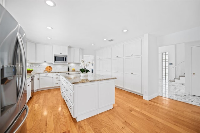 7545 Banyan Way, Tamarac, FL 33321 - kitchen with stainless steel appliances, light wood finished floors, white cabinetry, backsplash, and recessed lighting
