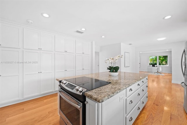 7545 Banyan Way, Tamarac, FL 33321 - kitchen with stainless steel appliances, light wood-style flooring, white cabinets, a center island, and recessed lighting