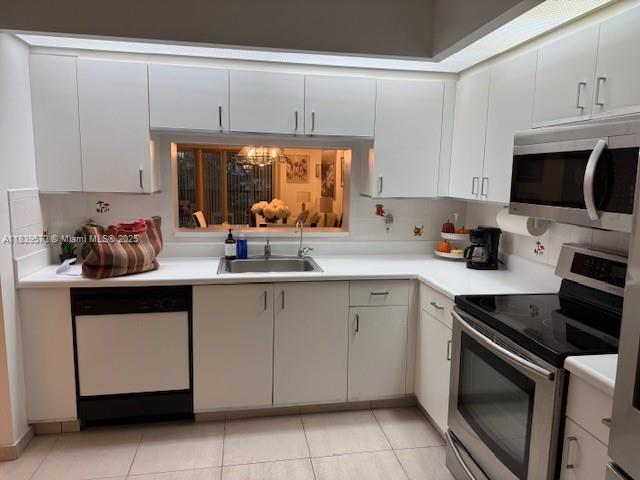 901 SW 141st Ave Unit 405M, Pembroke Pines, FL 33027 - kitchen featuring stainless steel appliances, light countertops, and light tile patterned flooring