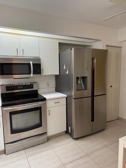 901 SW 141st Ave Unit 405M, Pembroke Pines, FL 33027 - kitchen with stainless steel appliances, light countertops, light tile patterned floors, and white cabinetry