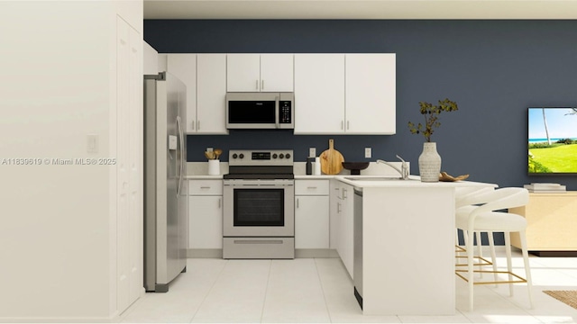 35713 SW 178th Ct, Miami, FL 33034 - kitchen featuring stainless steel appliances, a peninsula, a kitchen bar, white cabinetry, and light countertops