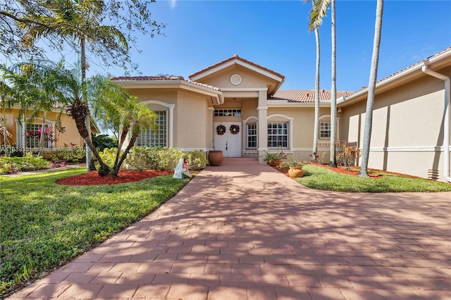 109 SW 128th Ave, Plantation, FL 33325 - view of front of house with stucco siding, a front yard, and a tile roof