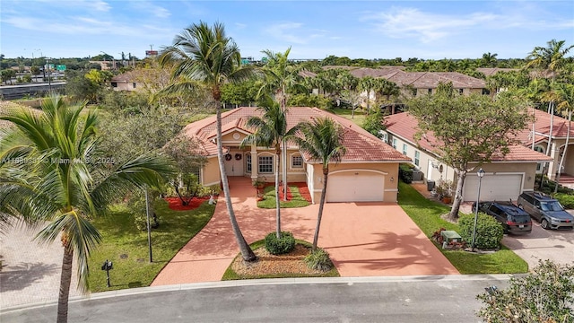 109 SW 128th Ave, Plantation, FL 33325 - view of front facade featuring stucco siding, driveway, a residential view, an attached garage, and a tiled roof