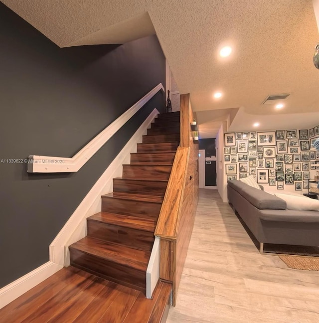 16652 Hemingway Dr, Weston, FL 33326 - stairs featuring a textured ceiling, wood finished floors, and recessed lighting
