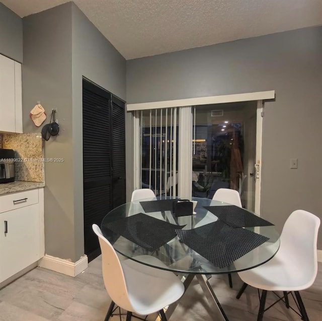 16652 Hemingway Dr, Weston, FL 33326 - dining room featuring a textured ceiling and baseboards