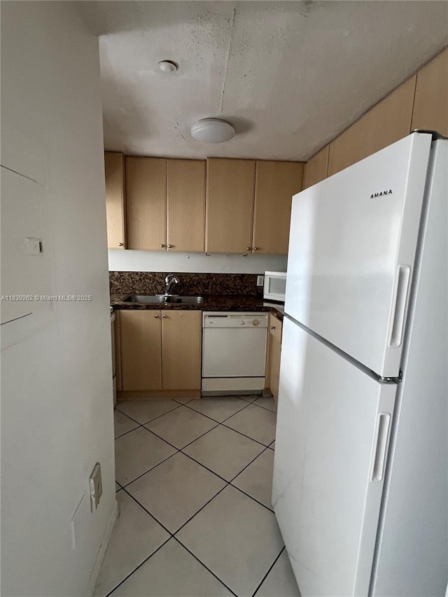 12645 SW 91st St Unit 202, Miami, FL 33186 - kitchen with white appliances, dark countertops, light tile patterned floors, and cream cabinetry