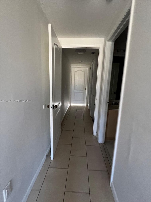 12645 SW 91st St Unit 202, Miami, FL 33186 - hallway featuring light tile patterned flooring and baseboards