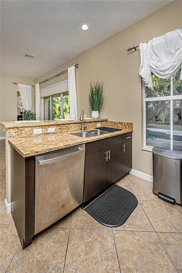10608 NW 36th St, Coral Springs, FL 33065 - kitchen with stainless steel dishwasher, dark brown cabinets, a textured ceiling, light stone countertops, and light tile patterned floors