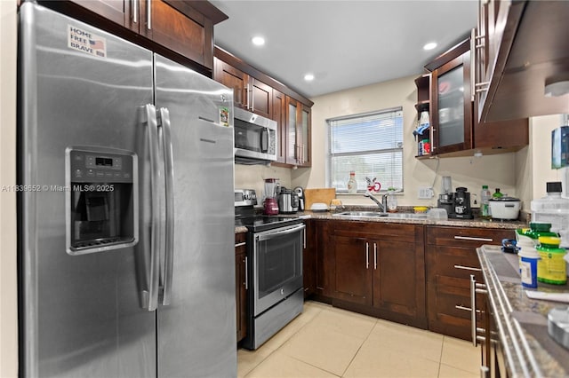 6600 Royal Palm Blvd Unit 103B, Margate, FL 33063 - kitchen featuring appliances with stainless steel finishes, dark stone countertops, light tile patterned floors, ventilation hood, and glass insert cabinets
