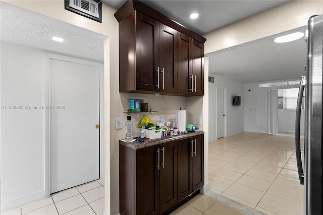 6600 Royal Palm Blvd Unit 103B, Margate, FL 33063 - kitchen with freestanding refrigerator, light tile patterned floors, dark brown cabinetry, recessed lighting, and dark countertops