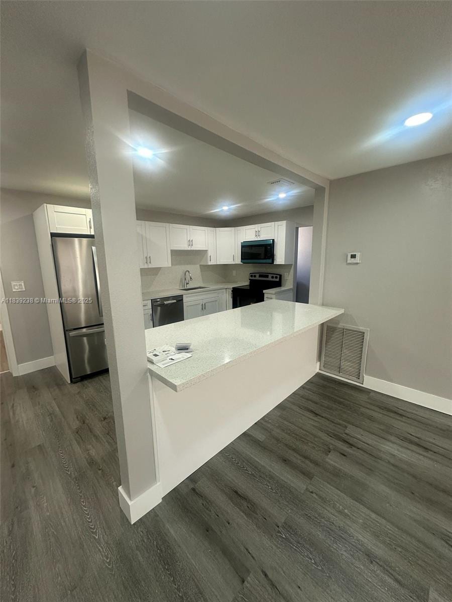6990 SW 28th St, Miramar, FL 33023 - kitchen with stainless steel appliances, a peninsula, white cabinets, and recessed lighting