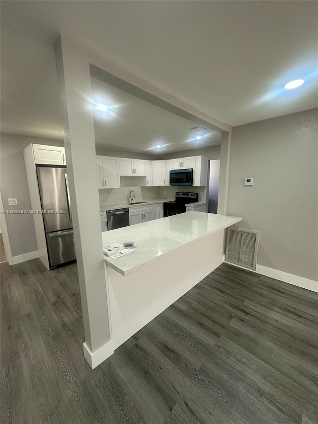 6990 SW 28th St, Miramar, FL 33023 - kitchen with stainless steel appliances, a peninsula, white cabinets, and recessed lighting