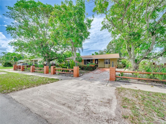 7140 Fillmore St, Hollywood, FL 33024 - ranch-style home featuring a fenced front yard, concrete driveway, and a gate