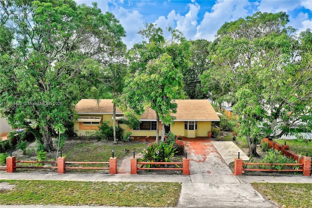7140 Fillmore St, Hollywood, FL 33024 - view of front facade featuring concrete driveway, a fenced front yard, a gate, stucco siding, and covered porch