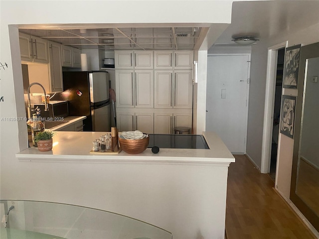 1228 W Ave Unit 911, Miami Beach, FL 33139 - kitchen featuring light countertops, freestanding refrigerator, wood finished floors, and a peninsula