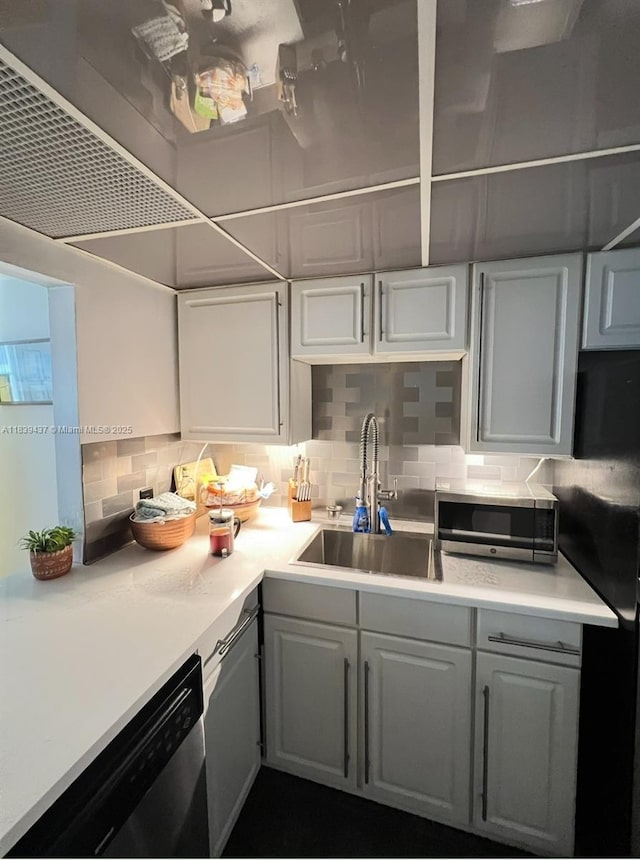 1228 W Ave Unit 911, Miami Beach, FL 33139 - kitchen with appliances with stainless steel finishes, decorative backsplash, light countertops, and gray cabinetry