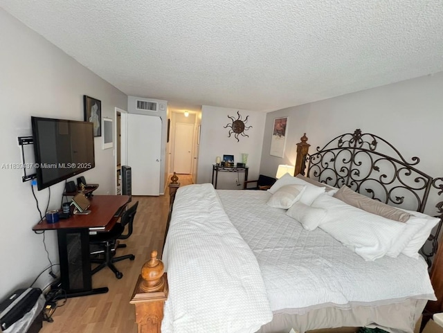1228 W Ave Unit 911, Miami Beach, FL 33139 - bedroom featuring light wood-style flooring, a textured ceiling, and a desk
