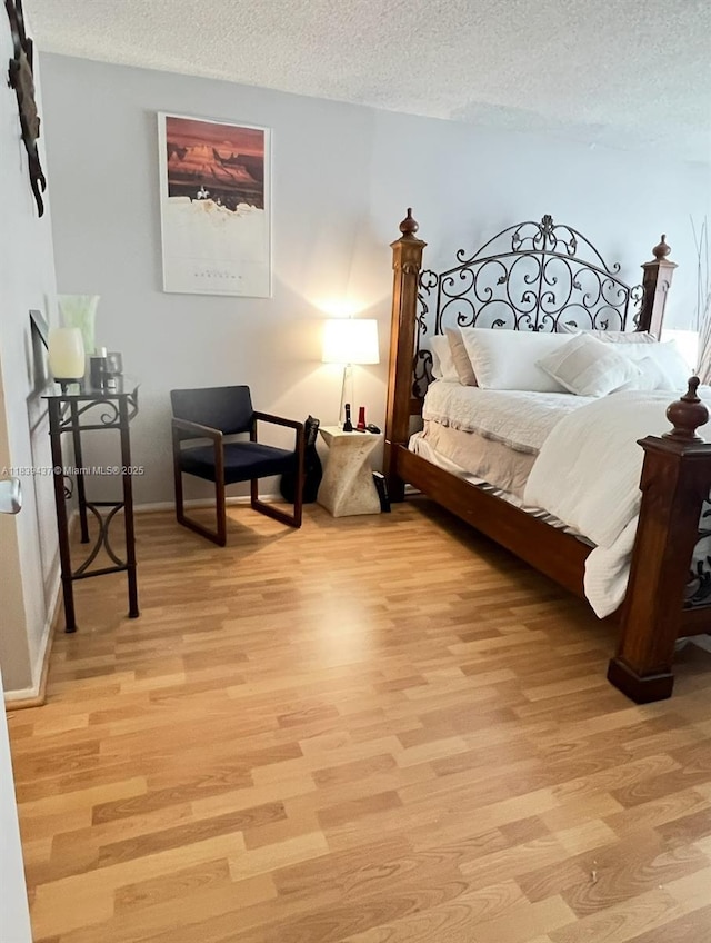 1228 W Ave Unit 911, Miami Beach, FL 33139 - bedroom with light wood finished floors and a textured ceiling