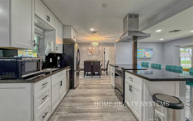 2359 Gabriel Ln, West Palm Beach, FL 33406 - kitchen featuring island exhaust hood, appliances with stainless steel finishes, dark countertops, white cabinetry, and recessed lighting
