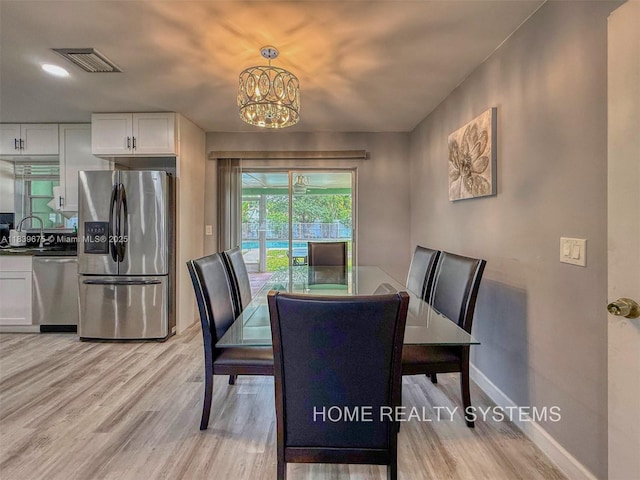 2359 Gabriel Ln, West Palm Beach, FL 33406 - dining area featuring a chandelier and light wood-style floors