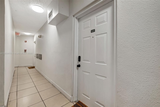 3051 SW 27th Ave Unit 402, Miami, FL 33133 - corridor with light tile patterned floors and a textured wall
