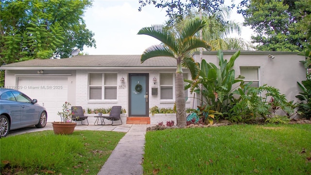 3521 SW 59th Ave, Miami, FL 33155 - view of front of house featuring an attached garage, a front yard, brick siding, and driveway