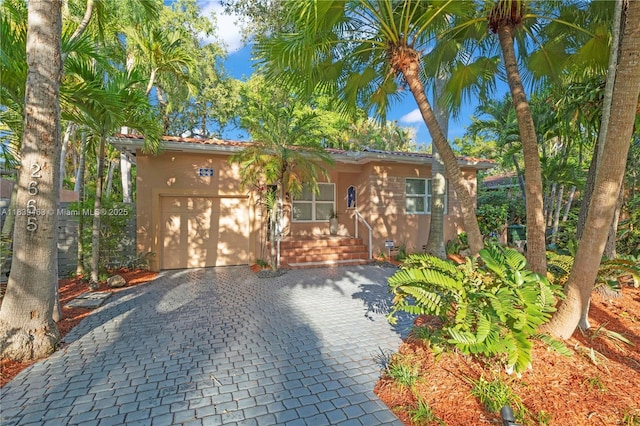 2665 SW 17th Ave, Miami, FL 33133 - view of front of home featuring stucco siding, decorative driveway, and a garage