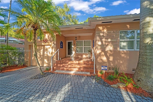 2665 SW 17th Ave, Miami, FL 33133 - view of exterior entry with stucco siding, decorative driveway, and covered porch