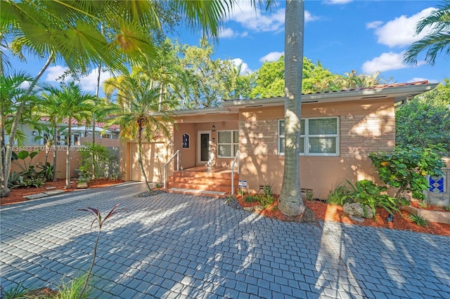 2665 SW 17th Ave, Miami, FL 33133 - view of front of house featuring decorative driveway, stucco siding, and an attached garage