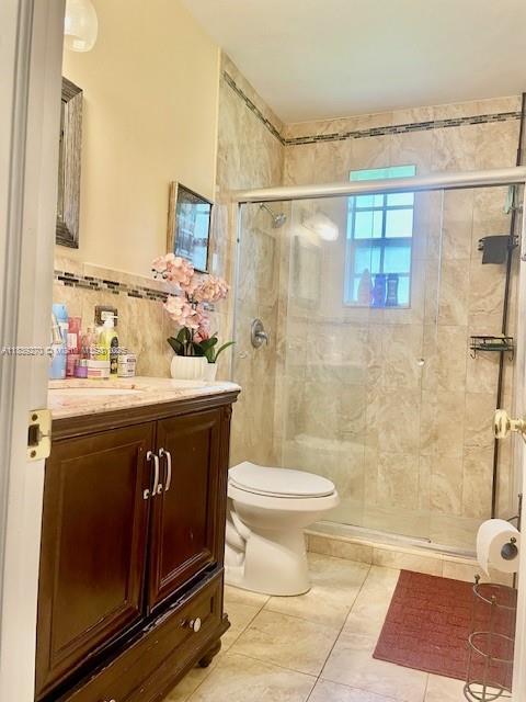 140 NW 199th St, Miami Gardens, FL 33169 - full bathroom with vanity, a stall shower, tile walls, and tile patterned flooring