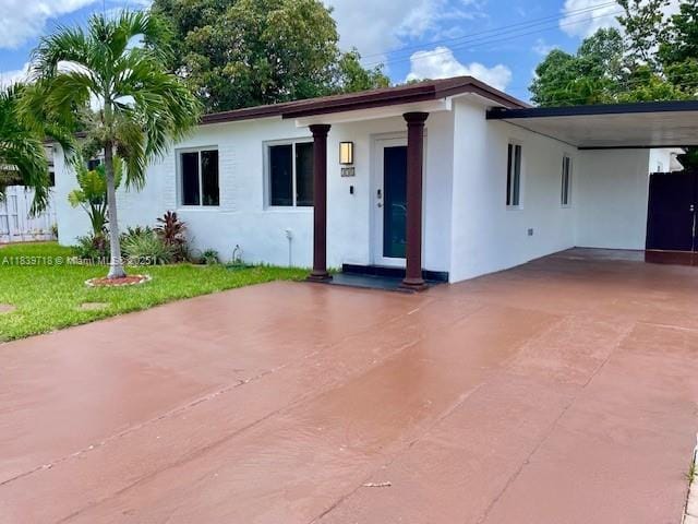 330 W 40th Pl, Hialeah, FL 33012 - ranch-style home featuring stucco siding, an attached carport, and concrete driveway