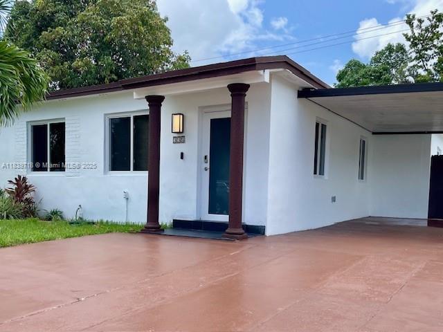 330 W 40th Pl, Hialeah, FL 33012 - view of front facade featuring stucco siding and a carport