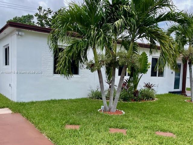 330 W 40th Pl, Hialeah, FL 33012 - view of side of property with a lawn and stucco siding