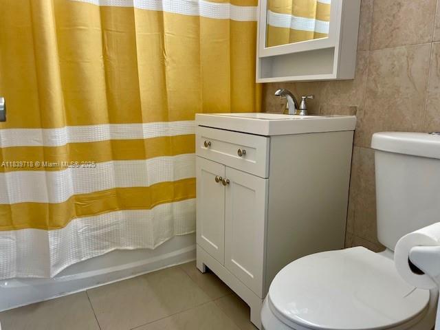 330 W 40th Pl, Hialeah, FL 33012 - bathroom featuring vanity, tile patterned flooring, shower / tub combo, and tile walls