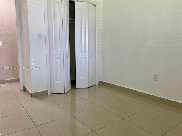 330 W 40th Pl, Hialeah, FL 33012 - unfurnished bedroom featuring light tile patterned flooring and a closet
