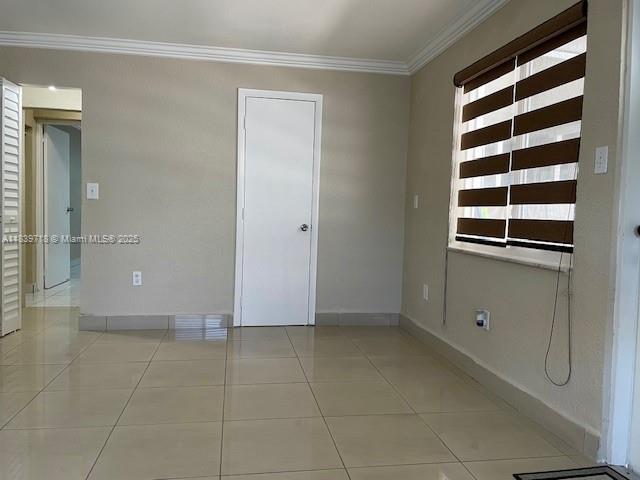 330 W 40th Pl, Hialeah, FL 33012 - tiled empty room with crown molding and baseboards