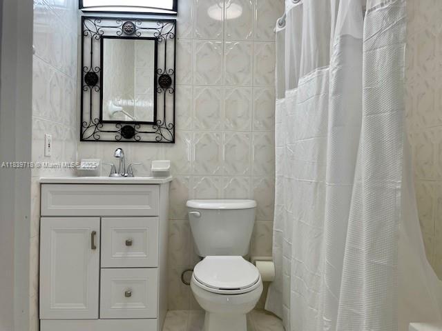 330 W 40th Pl, Hialeah, FL 33012 - full bathroom with vanity, tile walls, a shower with curtain, and tile patterned flooring