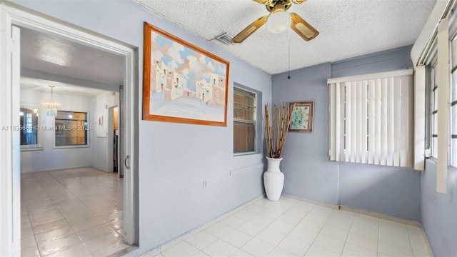 521 SE 5th St, Hialeah, FL 33010 - spare room featuring healthy amount of natural light, a ceiling fan, a chandelier, and a textured ceiling