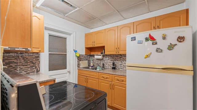 521 SE 5th St, Hialeah, FL 33010 - kitchen with freestanding refrigerator, decorative backsplash, range with electric stovetop, light countertops, and a paneled ceiling