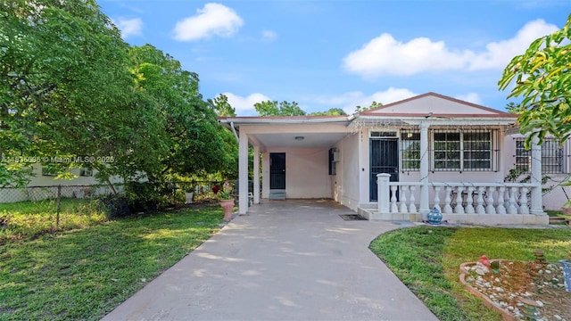 521 SE 5th St, Hialeah, FL 33010 - view of front of property featuring stucco siding, a carport, concrete driveway, and covered porch
