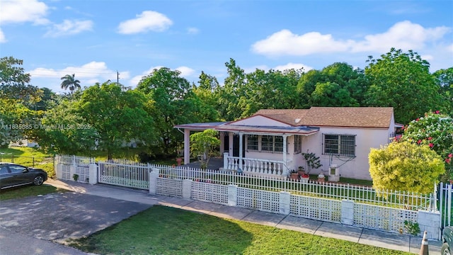 521 SE 5th St, Hialeah, FL 33010 - view of front facade featuring covered porch, a fenced front yard, stucco siding, and a gate
