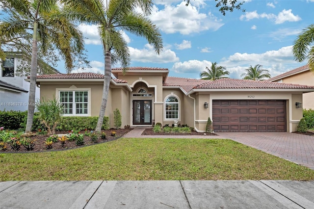 19252 N Hibiscus St, Weston, FL 33332 - mediterranean / spanish home featuring stucco siding, decorative driveway, an attached garage, a front yard, and french doors