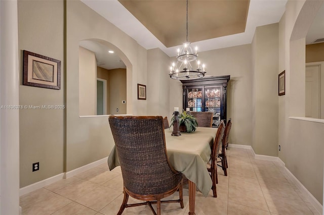 19252 N Hibiscus St, Weston, FL 33332 - dining room featuring arched walkways, a tray ceiling, and light tile patterned floors