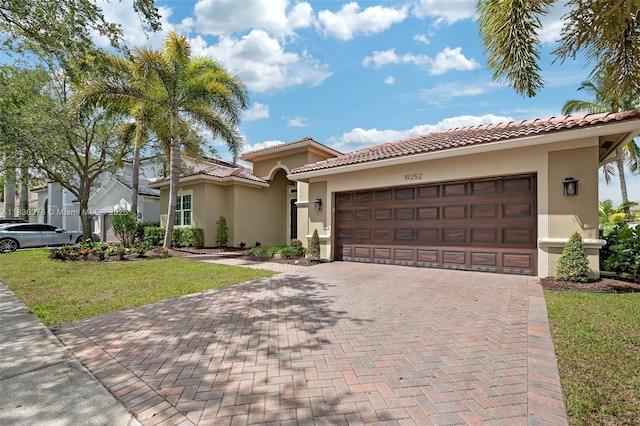 19252 N Hibiscus St, Weston, FL 33332 - mediterranean / spanish house with stucco siding, a front yard, an attached garage, and decorative driveway