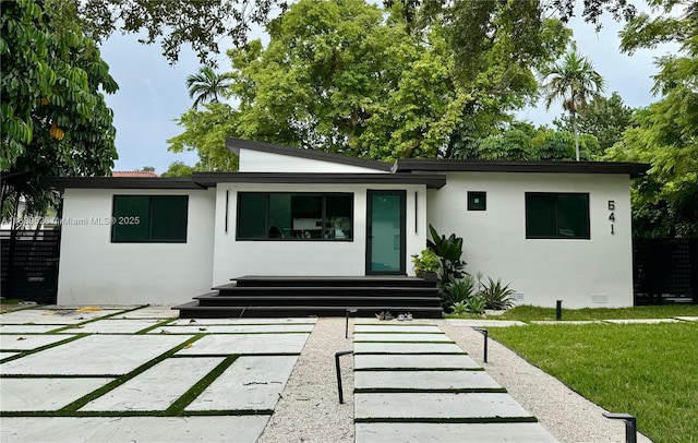 641 Nightingale Ave, Miami Springs, FL 33166 - back of house featuring stucco siding and a yard