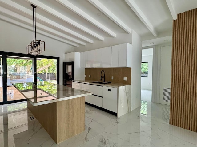 641 Nightingale Ave, Miami Springs, FL 33166 - kitchen with modern cabinets, backsplash, beamed ceiling, light marble finish floors, and refrigerator