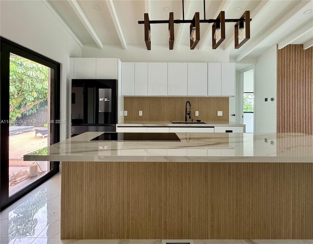 641 Nightingale Ave, Miami Springs, FL 33166 - kitchen featuring black electric stovetop, decorative backsplash, plenty of natural light, white cabinetry, and beamed ceiling