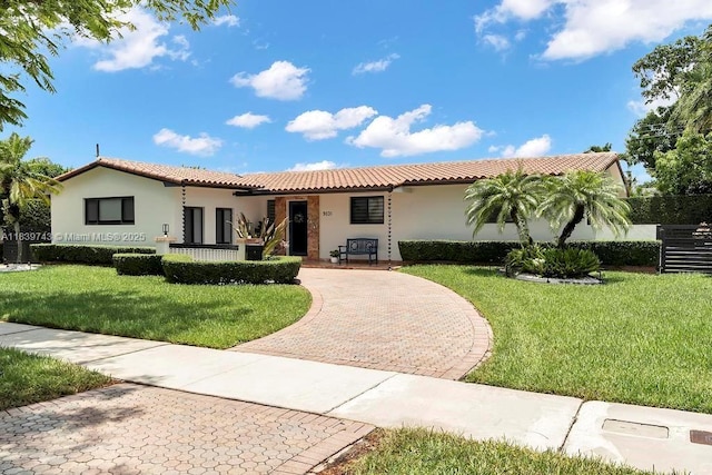 9031 SW 66th Ter, Miami, FL 33173 - mediterranean / spanish-style house with a tiled roof, stucco siding, and a front lawn