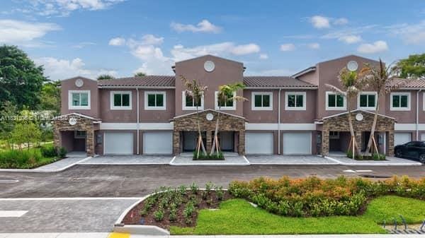 1563 NW 94th Way Unit 09, Coral Springs, FL 33071 - mediterranean / spanish house with an attached garage, stucco siding, stone siding, and driveway